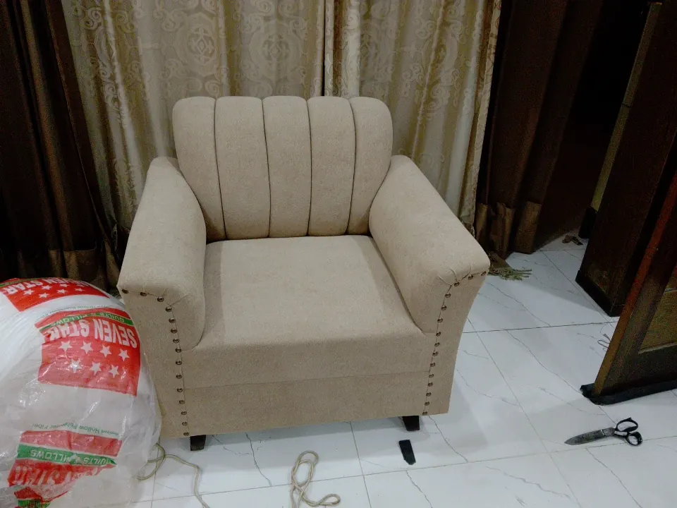 Beige channel-back armchair with nailhead trim
